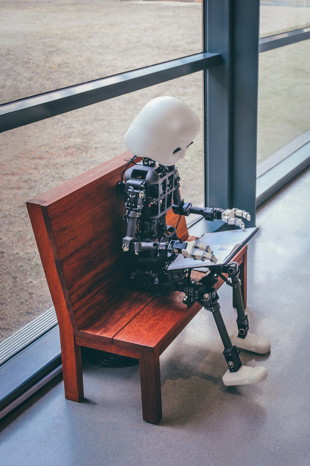 A robot sitting on a desk - waiting for AI answers to come back