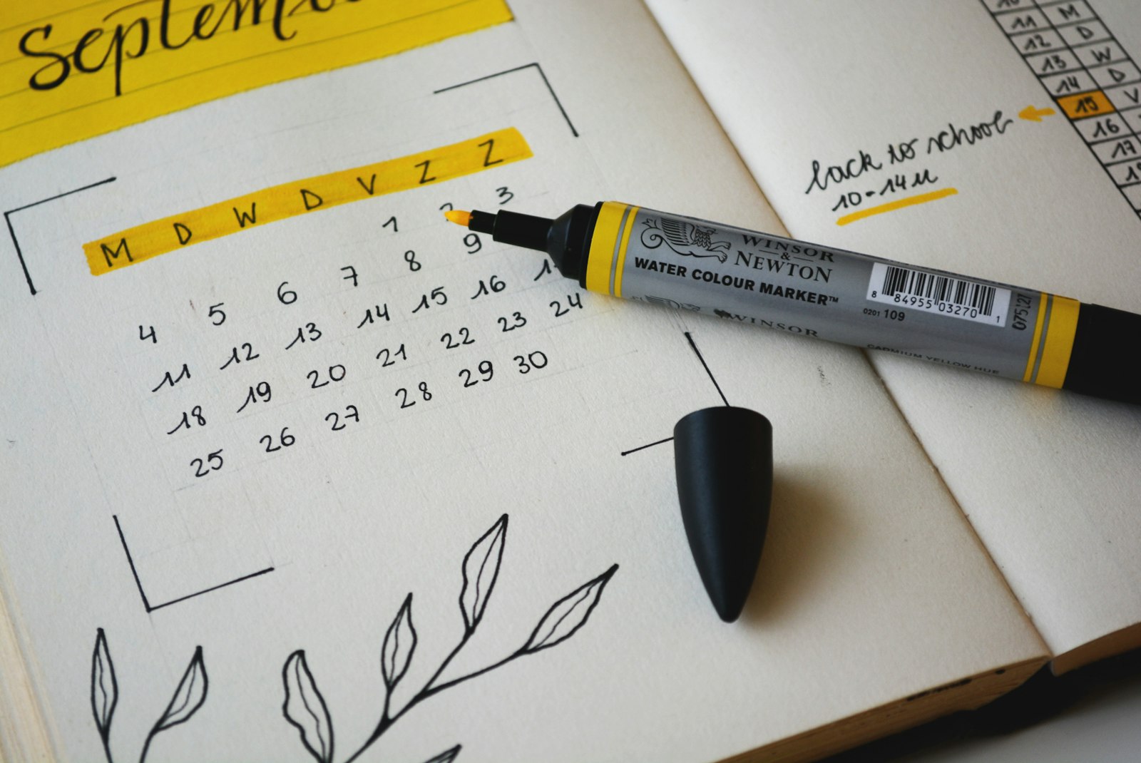 A hand-drawn September calendar in a notebook with a yellow marker, the days between sessions laid out in a grid